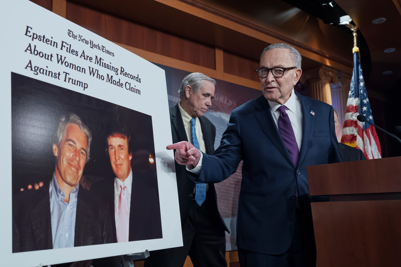 Senate Minority Leader Chuck Schumer, D-N.Y., joined at rear by Sen. Jeff Merkley, D-Ore., displays a photo of convicted sex trafficker Jeffrey Epstein with Donald Trump as they call for more accounta ...