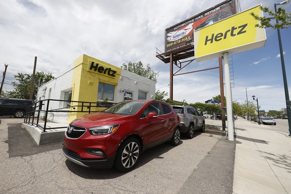 This May 23, 2020, photo shows rental vehicles parked outside a closed Hertz car rental office in south Denver. Hertz says it will pay approximately $168 million by the end of the year to settle the m ...