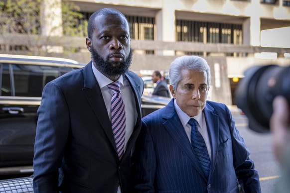 FILE - Prakazrel "Pras" Michel, left, a member of 1990s hip-hop group The Fugees, accompanied by attorney David Kenner, right, arrives at federal court for his trial in an alleged…
