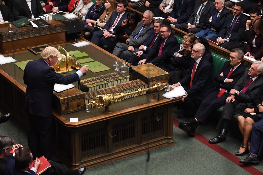 epa07869442 A handout photo made available by the UK Parliament shows British Prime Minister Boris Johnson (L) addressing MPs in front of labour leader jermy Corbyn (C-R) in the House of Commons in Lo ...