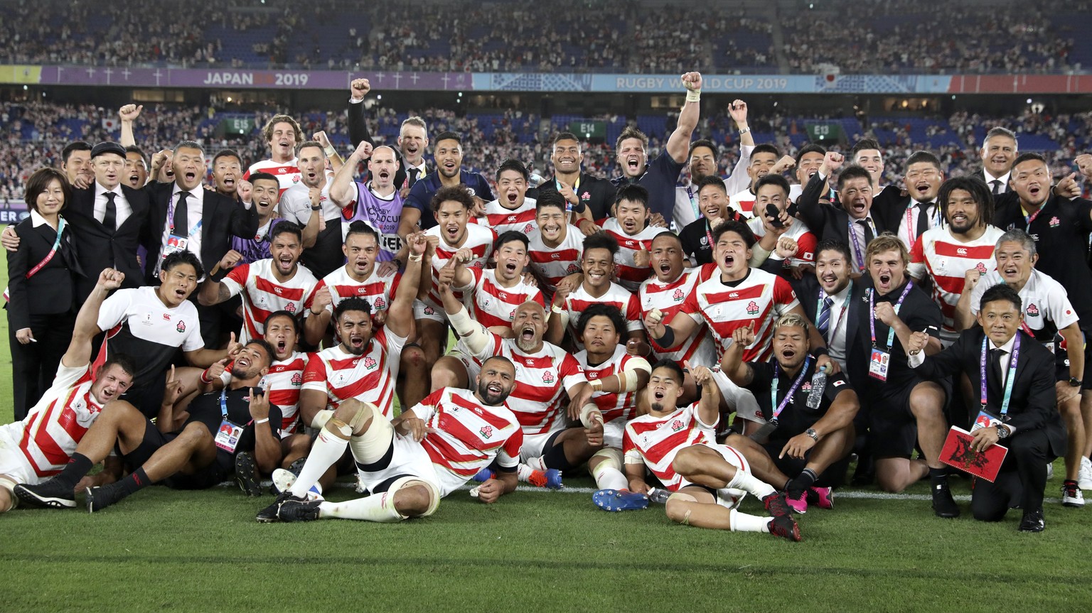 Japan players and management celebrate after defeating Scotland 28-21 in their Rugby World Cup Pool A game at International Stadium in Yokohama, Japan, Sunday, Oct. 13, 2019. (AP Photo/Christophe Ena)