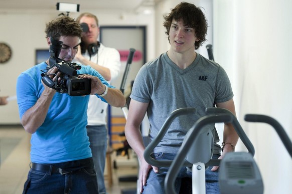 Kevin Loetscher, Eishockeyspieler des SC Bern,rechts, sitzt auf einem Hometrainer im Anna Seiler Haus des Inselspitals, am Donnerstag 1. September 2011, in Bern. Loetscher wurde am 14. Mai 2011 bei ei ...