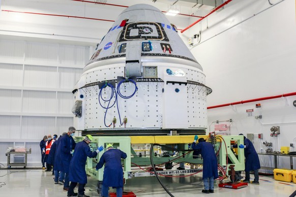 In this June 2, 2021 photo made available by NASA, technicians prepare Boeing&#039;s CST-100 Starliner for the company&#039;s Orbital Flight Test-2 (OFT-2) in the Commercial Crew and Cargo Processing  ...