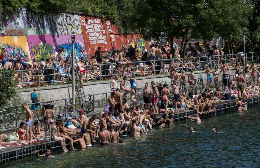 Menschen sonnen sich an der Limmat, aufgenommen am Pfingst-Montag, 9. Juni 2014 am Letten in Zuerich. Das hochsommerliche Wetter am Pfingstwochenende hat den Schweizer Freibaedern einen Besucheranstur ...