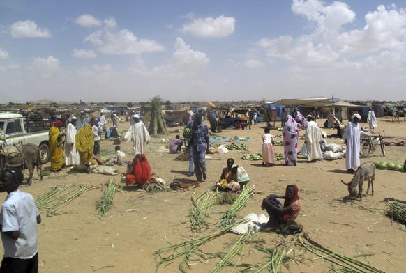 FILE - People prepare local crops of sugar cane and watermelons for sale, at Abu Shouk refugee camp, where they live on the outskirts of El Fasher, North Darfur, Sudan, Oct. 8, 2010. (AP Photo/John He ...