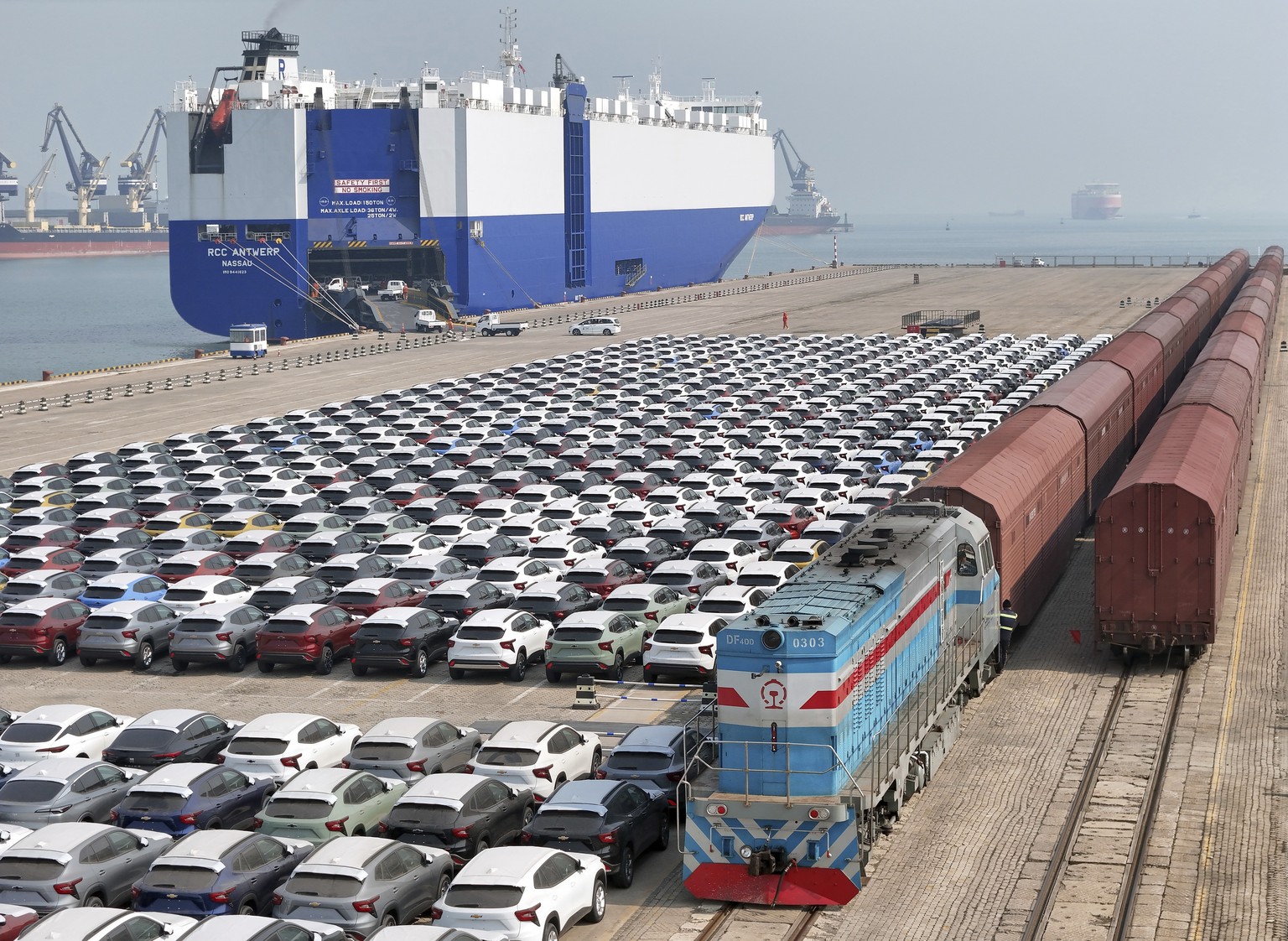FILE - A freight train carrying cars to be exported arrives at a dock for ro-ro shipping in Yantai in eastern China&#039;s Shandong province Sunday, March 3, 2024. China?s exports contracted in March  ...