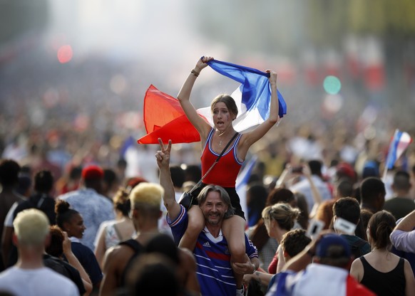 People celebrate on the Champs Elysees avenue after France won the soccer World Cup final match between France and Croatia, Sunday, July 15, 2018 in Paris. France won its second World Cup title by bea ...