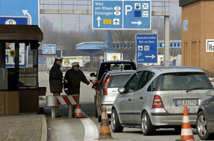 JAHRESRUECKBLICK 2004 - WIRTSCHAFT - STOCKENDER GRENZVERKEHR ZWISCHEN DEUTSCHLAND UND DER SCHWEIZ: Officers of the German border police check the cars entering Germany at the Swiss-German border cross ...