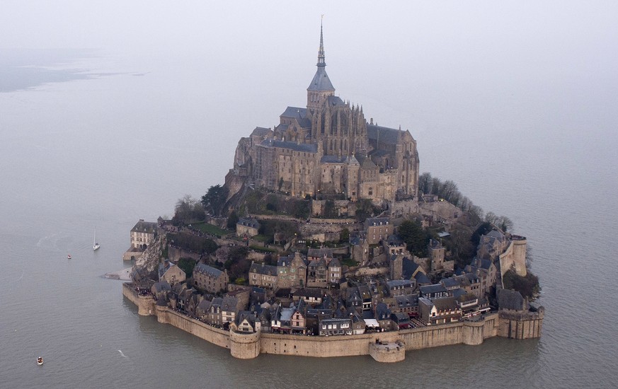 FILE - In this March 21, 2015 file photo, a high tide submerges a narrow causeway leading to the Mont Saint-Michel, on France&#039;s northern coast. Authorities are evacuating tourists and others from ...