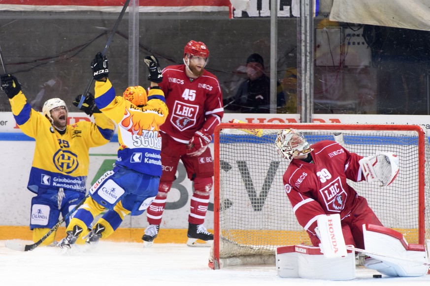 Le gardien lausannois Cristobal Huet, droite, et le defenseur lausannois Jonas Junland, centre, montrent leur deception apres le 3eme but devant la joie le defenseur davosiens Beat Forster, gauche, et ...