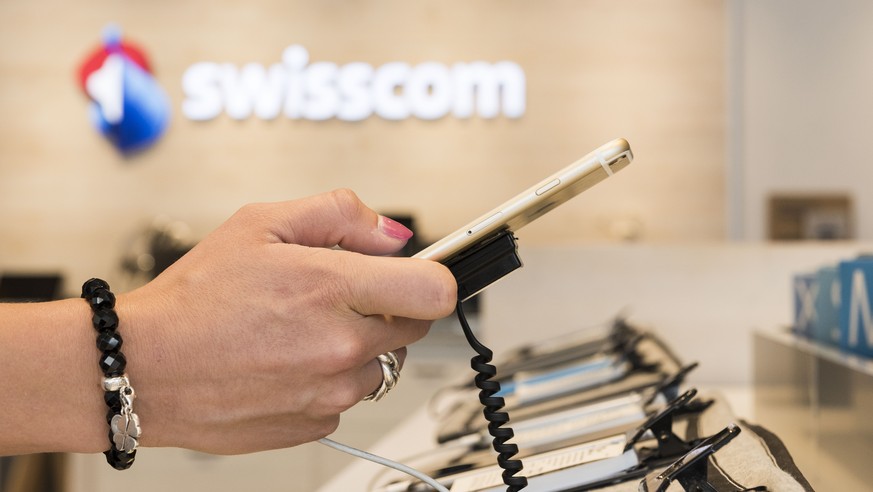 ARCHIVBILD ZUM UMSATZ DER SWISSCOM IM ERSTEN QUARTAL 2017, AM MITTWOCH, 3. MAI 2017 - A customer tests a mobile phone at a Swisscom Shop of the telecommunications provider Swisscom AG on Avenue Bergie ...