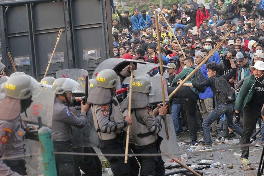 Student protesters use sticks to attack riot police during a protest outside the parliament in Jakarta, Indonesia, Tuesday, Sept. 24, 2019. Thousands of students have staged rallies across Indonesia a ...