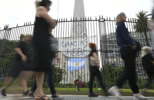Members of the Mothers of Plaza de Mayo and HIJOS human rights organizations, made up of the mothers and children of the disappeared, march past the Pyramid of Mayo that is covered with portraits of m ...