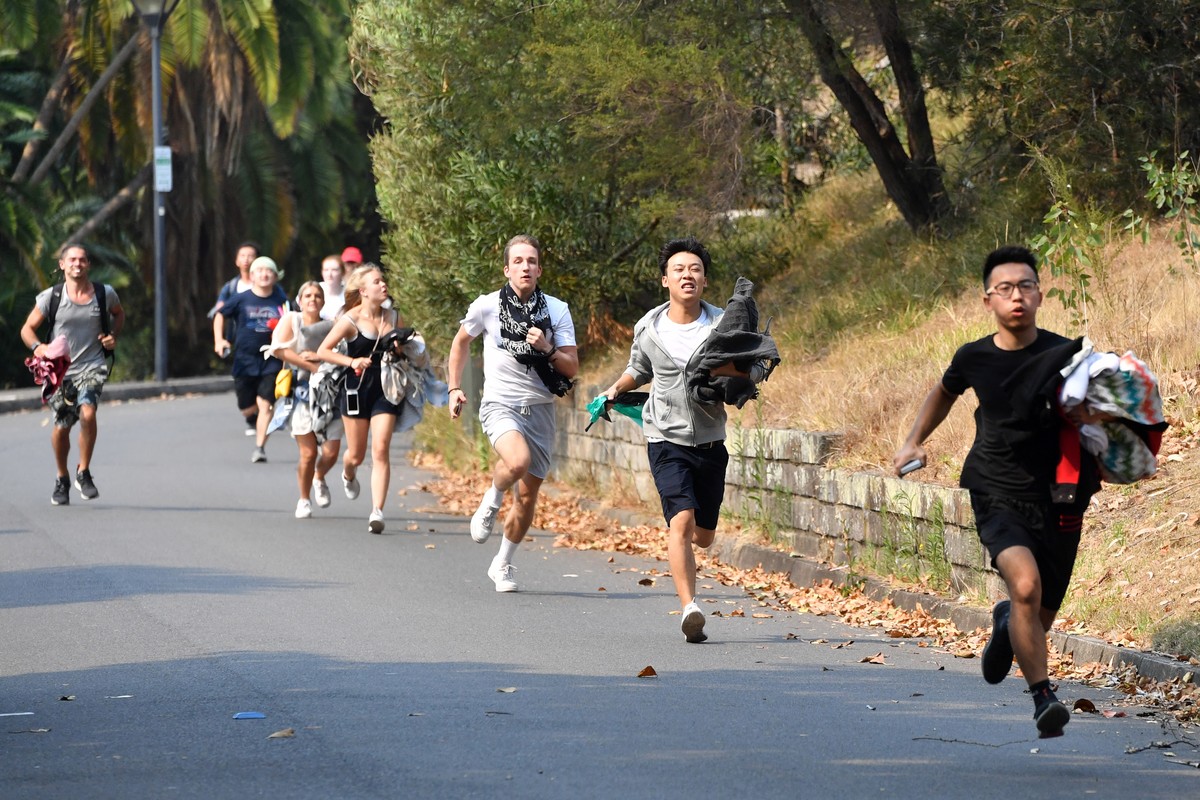 epa08095386 Members of the public run to secure positions at Mrs Macquarie's Chair on the eve of a New Year's fireworks display in Sydney, Australia, 31 December 2019. EPA/MICK TSIKAS AUSTRA ...