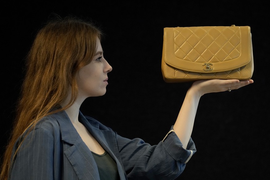 A Bonhams employee displays a beige lambskin medium Chanel &#039;Diana&#039; bag (1991 - 94) in London, Wednesday, Oct. 6, 2021. The Diana single flap bag was produced for only a few years in the earl ...