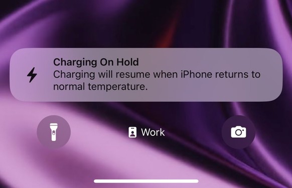 Charging stopped due to overheating on an iPhone 15 Pro Max.