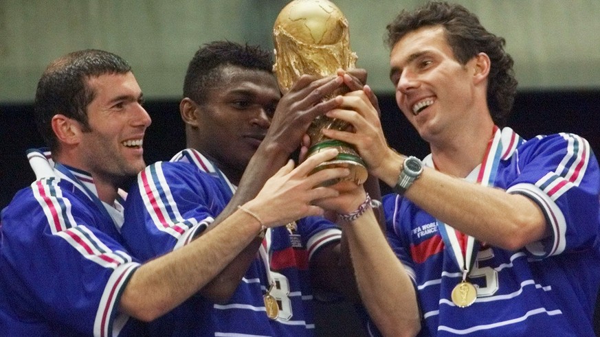 FILE - In this Sunday, July 12, 1998 file photo, French teammates from left, Zinedine Zidane, Marcel Desailly and Laurent Blanc hold the soccer World Cup after France defeated Brazil 3-0 in the World  ...