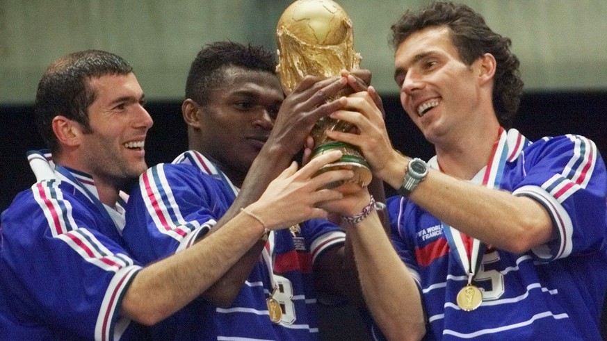 FILE - In this Sunday, July 12, 1998 file photo, French teammates from left, Zinedine Zidane, Marcel Desailly and Laurent Blanc hold the soccer World Cup after France defeated Brazil 3-0 in the World ...