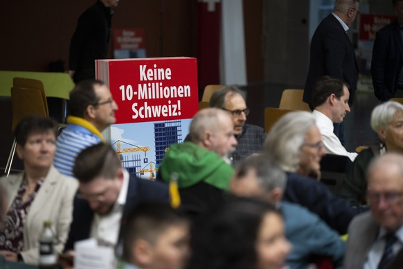 Ein Plakat mit der Aufschrift Keine 10-Millionen-Schweiz! Nachhaltigkeits-Initiative Ja - aufgenommen an der Delegiertenversammlung der SVP Schweiz, am Samstag, 28. Maerz 2026, in Maienfeld. (KEYSTONE ...