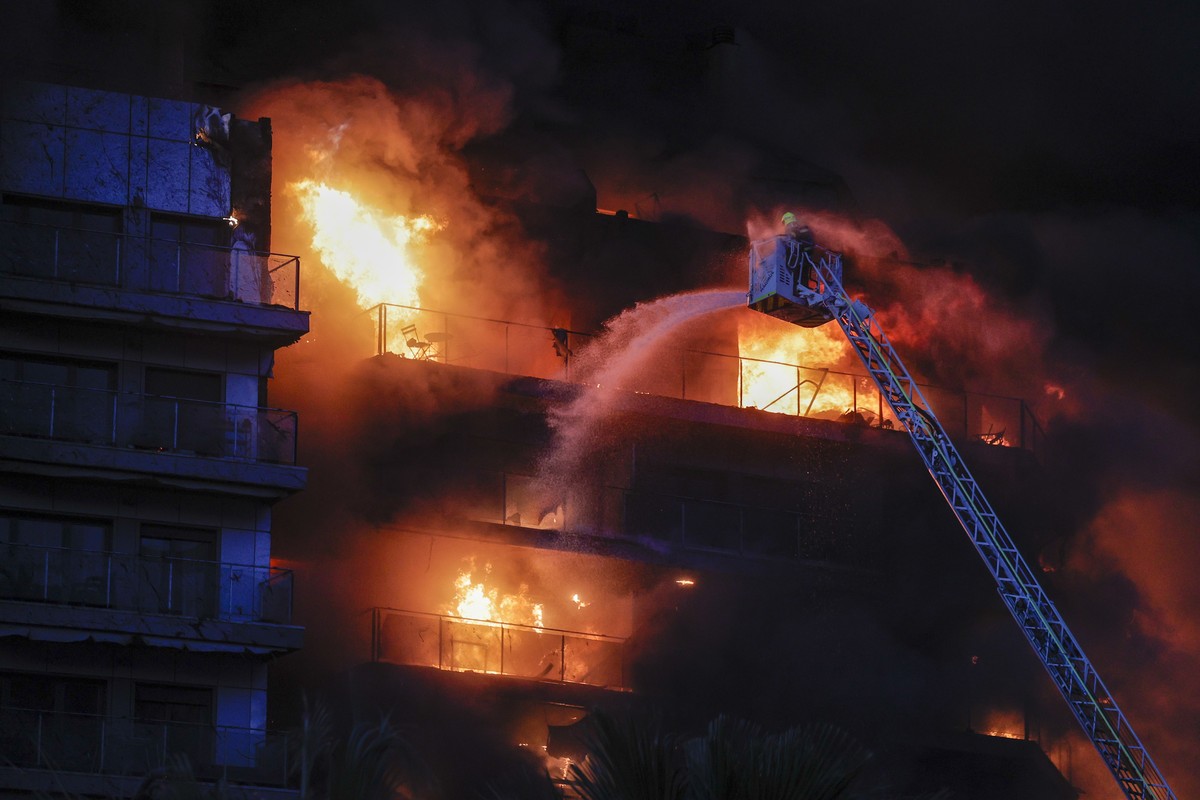 epa11173259 Firemen try to extinguish a fire of a 14-story residential building in Valencia, eastern Spain, 22 February 2024. At least seven people were injured during the ongoing fire, and two people ...