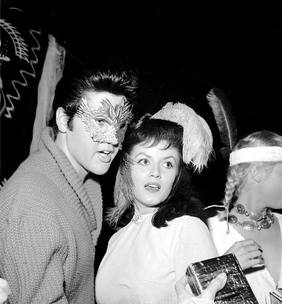 OCTOBER 31: Rock and roll singer Elvis Presley wearing a mask for a Halloween party with Joan Bradshaw on October 31, 1957 in Los Angeles, CA. (Photo by Michael Ochs Archives/Getty Images)
Use informa ...