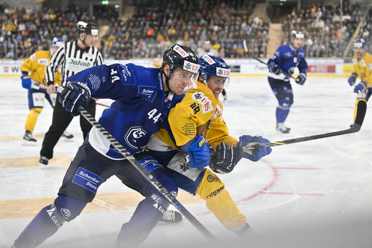 epa10382994 Ambri's Andre Heim (L) versus Davos' Marc Michaelis in action during the match between Switzerland's HC Ambri-Piotta and HC Davos at the 94th Spengler Cup ice hockey tournam ...