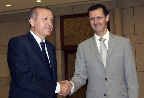 FILE - Syrian President Bashar Assad, right, shakes hands with Turkish Prime Minister Recep Tayyip Erdogan, left, at al-Shaab presidential palace in Damascus, Syria, Monday Oct. 11, 2010. Turkish Pres ...