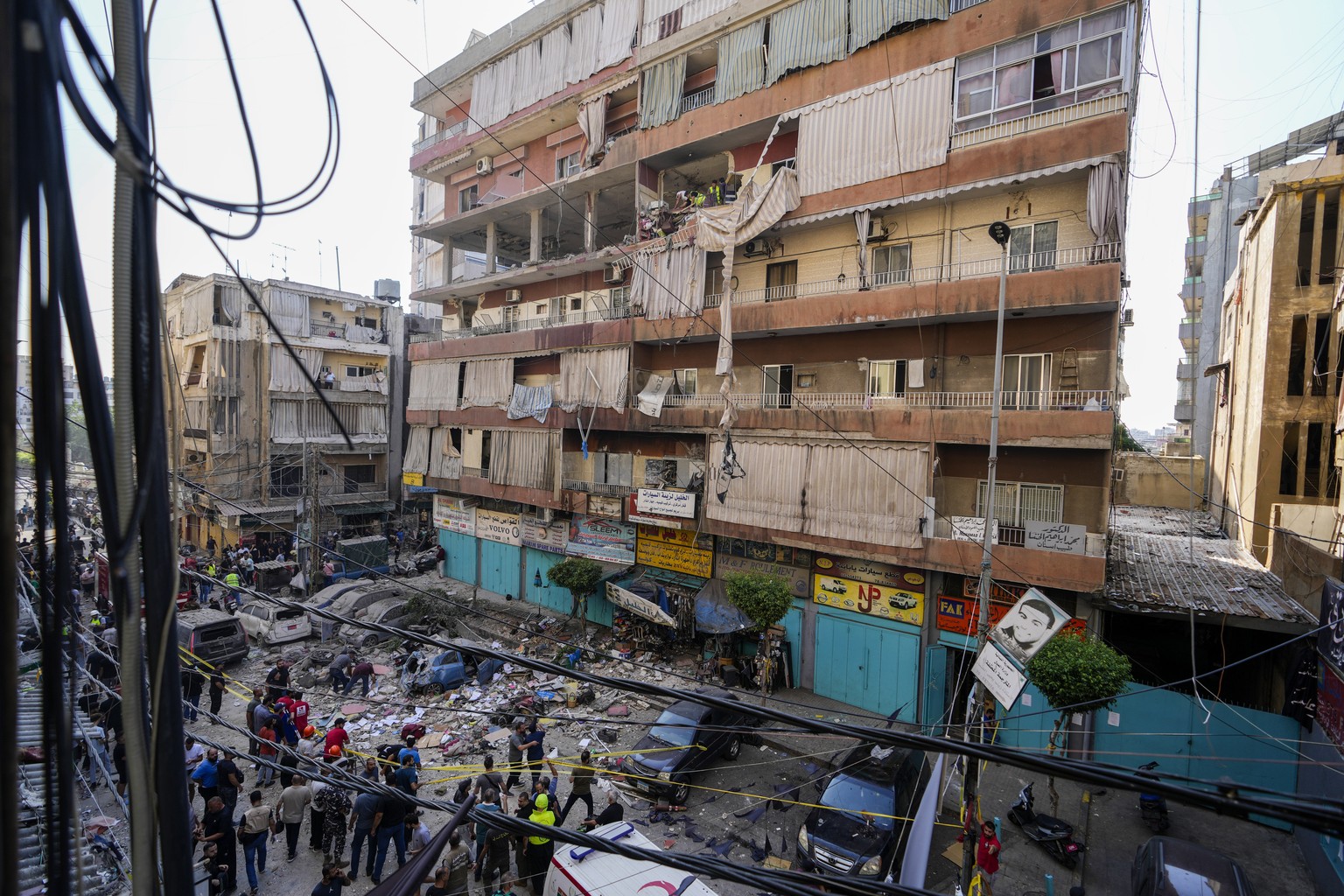 Residents and rescuers check a building that was hit by an Israeli airstrike in Beirut&#039;s southern suburbs, Tuesday, Sept. 24, 2024. (AP Photo/Hassan Ammar)