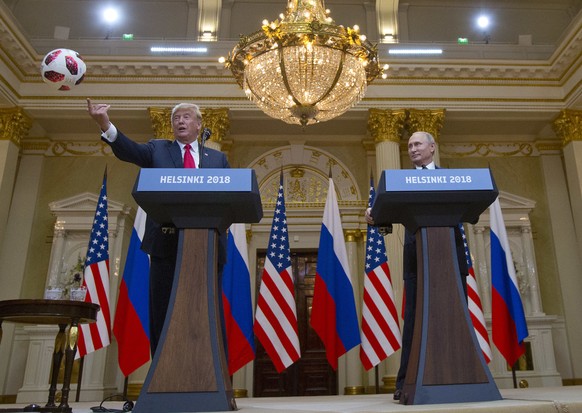 U.S. President Donald Trump, left, tosses a soccer ball to his wife first lady Melania Trump after Russian President Vladimir Putin presented it to him during a press conference after their meeting at ...