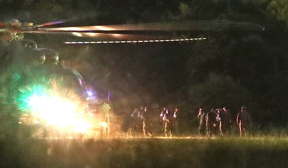 epa06873793 Thai medics and police officers evacuate the first two children with a helicopter after rescued from Tham Luang cave before heading to hospital, at a helicopter pad in Chiang Rai province, ...