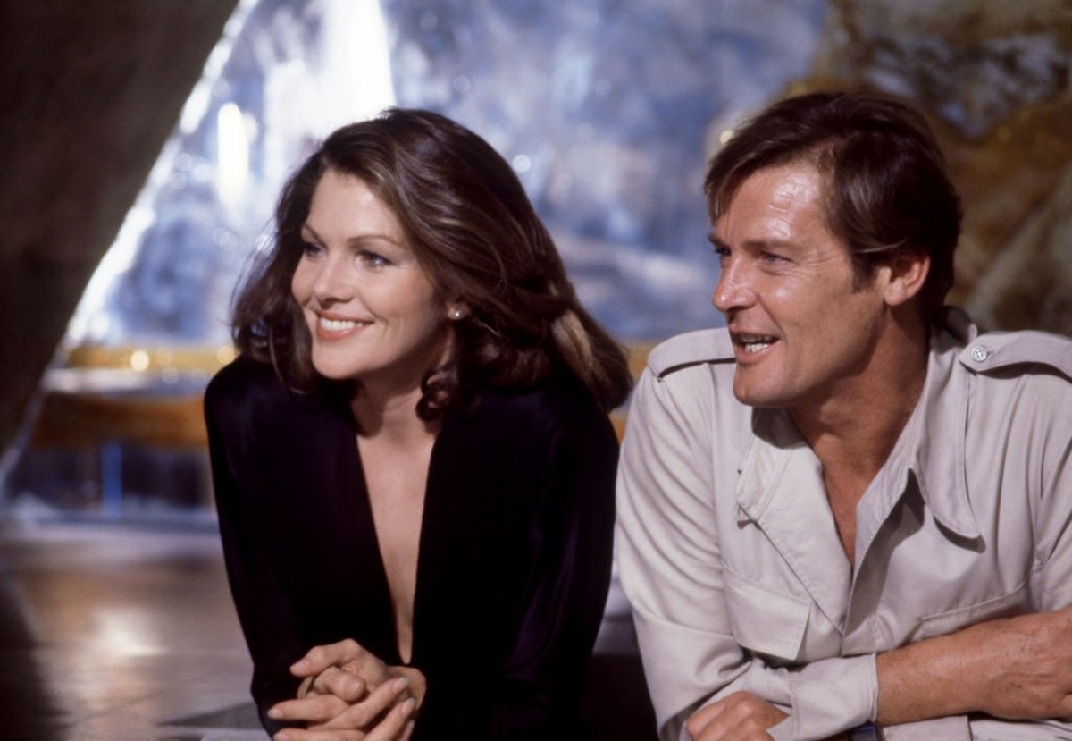 (L-R) American actress Lois Chiles, is Holly Goodhead, and English actor Roger Moore (1927 - 2017), is James Bond, during the filming of the 1979 James Bond spy movie, Moonraker in the United Kingdom, ...