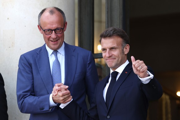 French President Emmanuel Macron, right, greets German Chancellor Friedrich Merz ahead of a multinational virtual summit at the Elysee Presidential Palace in Paris, Friday April 17, 2026 (Tom Nicholso ...