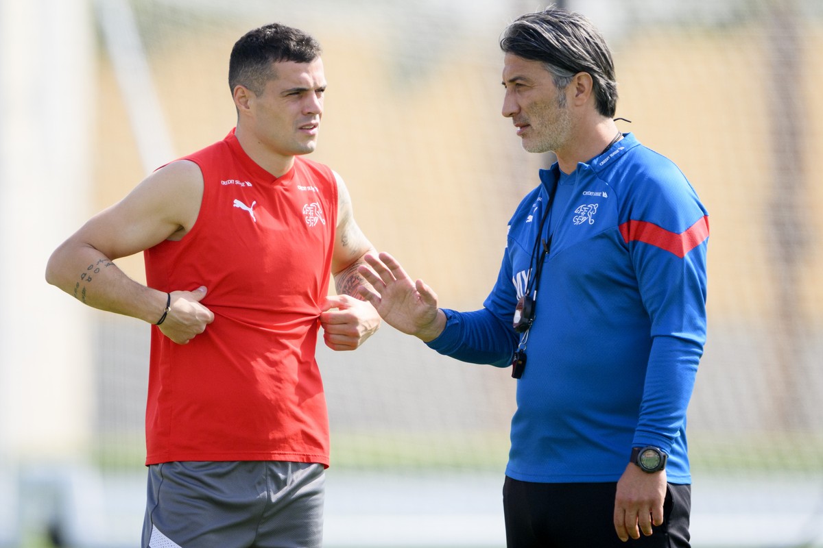 Switzerland's head coach Murat Yakin, right, speaks with Switzerland's midfielder Granit Xhaka, left, during a closed training session of Swiss national soccer team in preparation for the FI ...