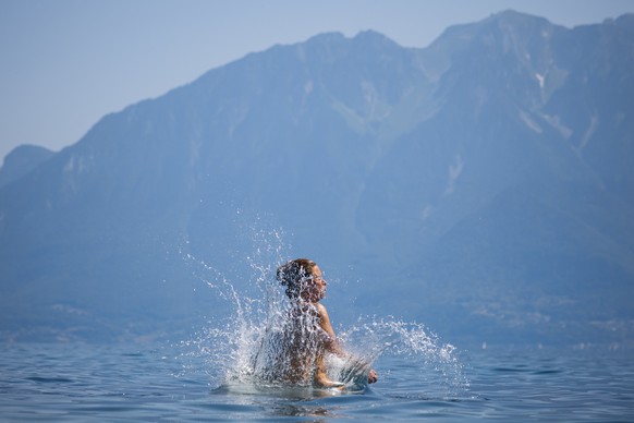 epa10020546 A woman jumps into lake Geneva as a heat wave reaches the country, in Saint-Saphorin, Switzerland, 18 June 2022. EPA/VALENTIN FLAURAUD