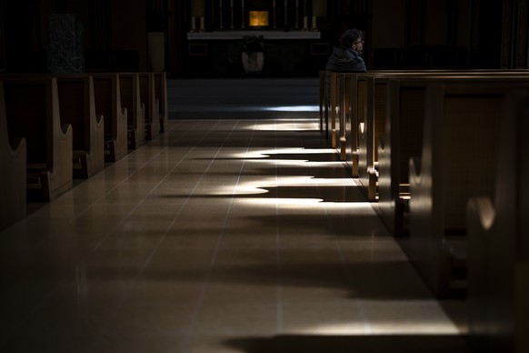 Ein Mann sitzt auf einem Kirchenbank und hoert zu waehrend einer Medienkonferenz zu einer Reputationsumfrage der Katholische Kirche des Kantons Zuerich, am Dienstag, 1. April 2025 in der Katholischen  ...