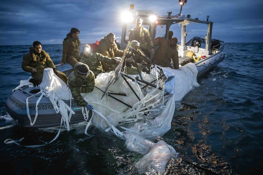 In this photo provided by the U.S. Navy, sailors assigned to Explosive Ordnance Disposal Group 2 recover a high-altitude surveillance balloon off the coast of Myrtle Beach, S.C., Feb. 5, 2023. (U.S. N ...