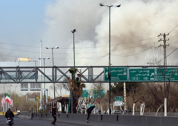 epa12796798 People run for safety as smoke rises after an airstrike in central Tehran, Iran, 05 March 2026. A joint Israeli and US military operation continues to target multiple locations across Iran ...