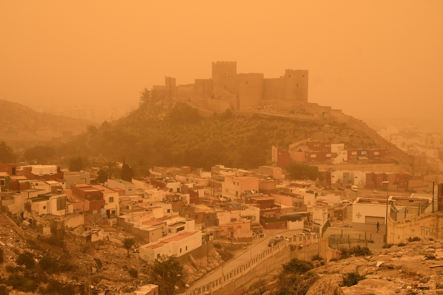 epa09826993 A general view of the Almeria fortress covered in orange as result of the airbone dust from Sahara desert in Almeria, southeastern Spain, 15 March 2022. A wave of airborne dust from the Sa ...