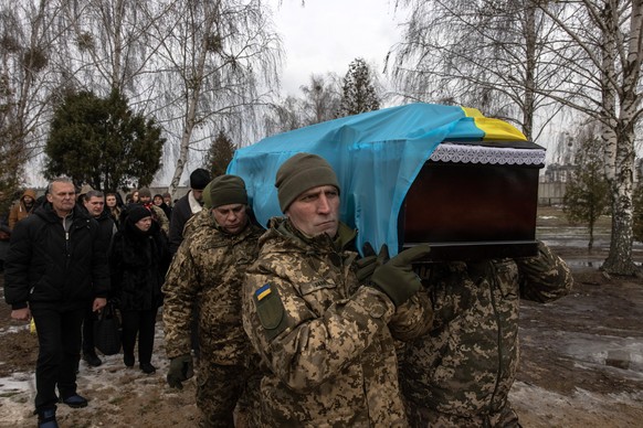 epa10377191 Ukrainian servicemen carry the coffin containing Ukrainian soldier Dmytro Kyrychenko during the funeral ceremony at a cemetery in Bucha, northwest of Kiev, Ukraine, December 23, 2022. A 33-year-old ...
