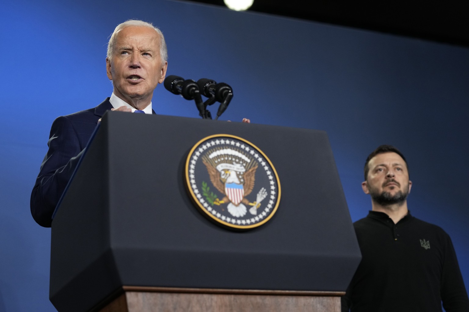 FILE - President Joe Biden, left, joined by President of Ukraine Volodymyr Zelenskyy, speaks during an event on the Ukraine Compact on the sidelines of the NATO Summit in Washington, Thursday, July 11 ...