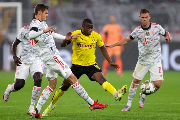 epa09418224 Dortmund&#039;s Youssoufa Moukoko (C) in action against Bayern&#039;s Josip Stanisic (L) during the DFL Supercup 2021 soccer match between Borussia Dortmund and FC Bayern Muenchen in Dortm ...