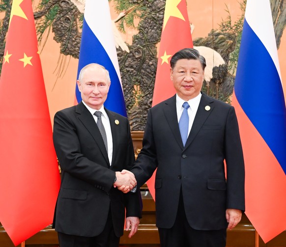 epa10925981 Chinese President Xi Jinping shakes hasnds with Russian President Vladimir Putin at the Great Hall of the People in Beijing, China, 18 October 2023. Putin is in Beijing for the third Belt  ...