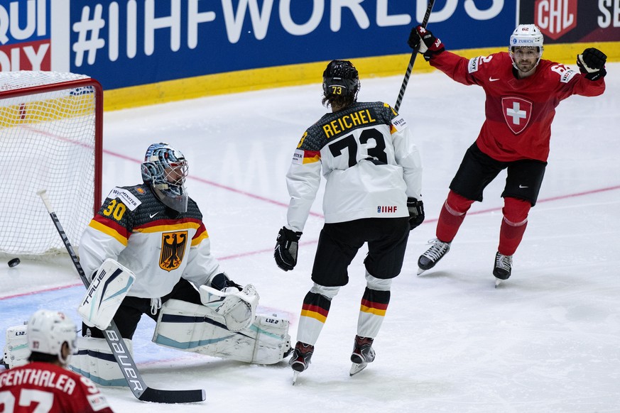 epa09971427 Switzerland&#039;s Denis Malgin (R) celebrates his team&#039;s 2-2 equalizer against Germany&#039;s goalie Philipp Grubauer (L) and Lukas Reichel (C) during the IIHF Ice Hockey World Champ ...