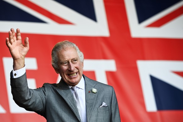 epa10876750 Britain&#039;s King Charles III waves to the crowd under a giant Union flag during a visit to a festival in celebration of British and French culture and business at Place de la Bourse in  ...