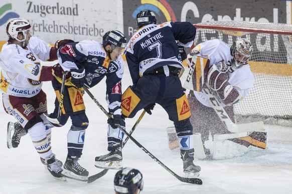 Reto Suri, 2. von links, von Zug im Spiel gegen Torhueter Robert Mayer, rechts, von Servette beim Eishockey Meisterschaftsspiel in der Qualifikation der National League zwischen dem EV Zug und Servett ...