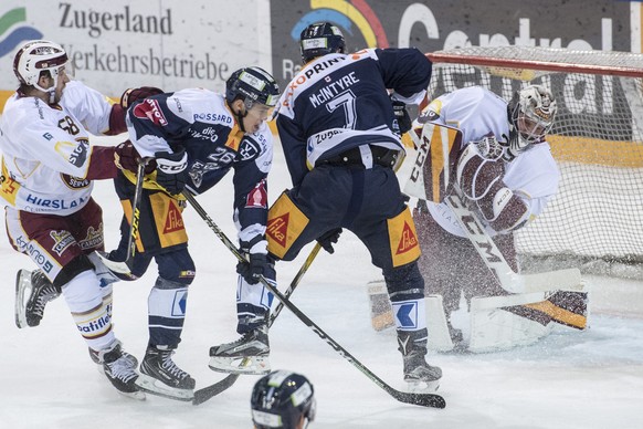 Reto Suri, 2. von links, von Zug im Spiel gegen Torhueter Robert Mayer, rechts, von Servette beim Eishockey Meisterschaftsspiel in der Qualifikation der National League zwischen dem EV Zug und Servett ...