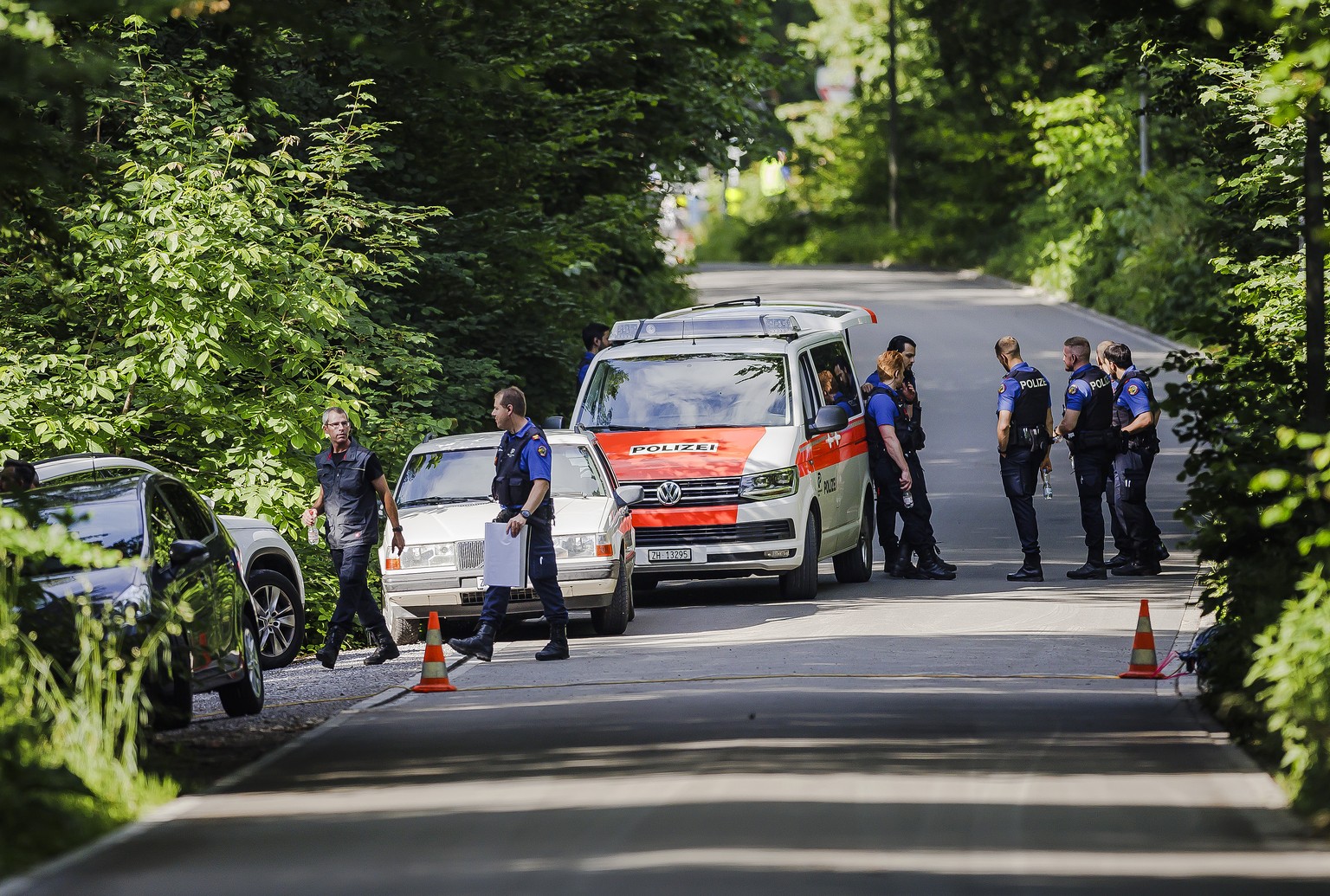 Polizisten und Einsatzfahrzeuge der Polizei auf der gesperrten Seebacherstrasse im Huerstwald, am Mittwoch, 8. Juni 2022 in Zuerich. Nachdem die Polizei bereits am 5. Mai eine Suchaktion im Zuercher H ...