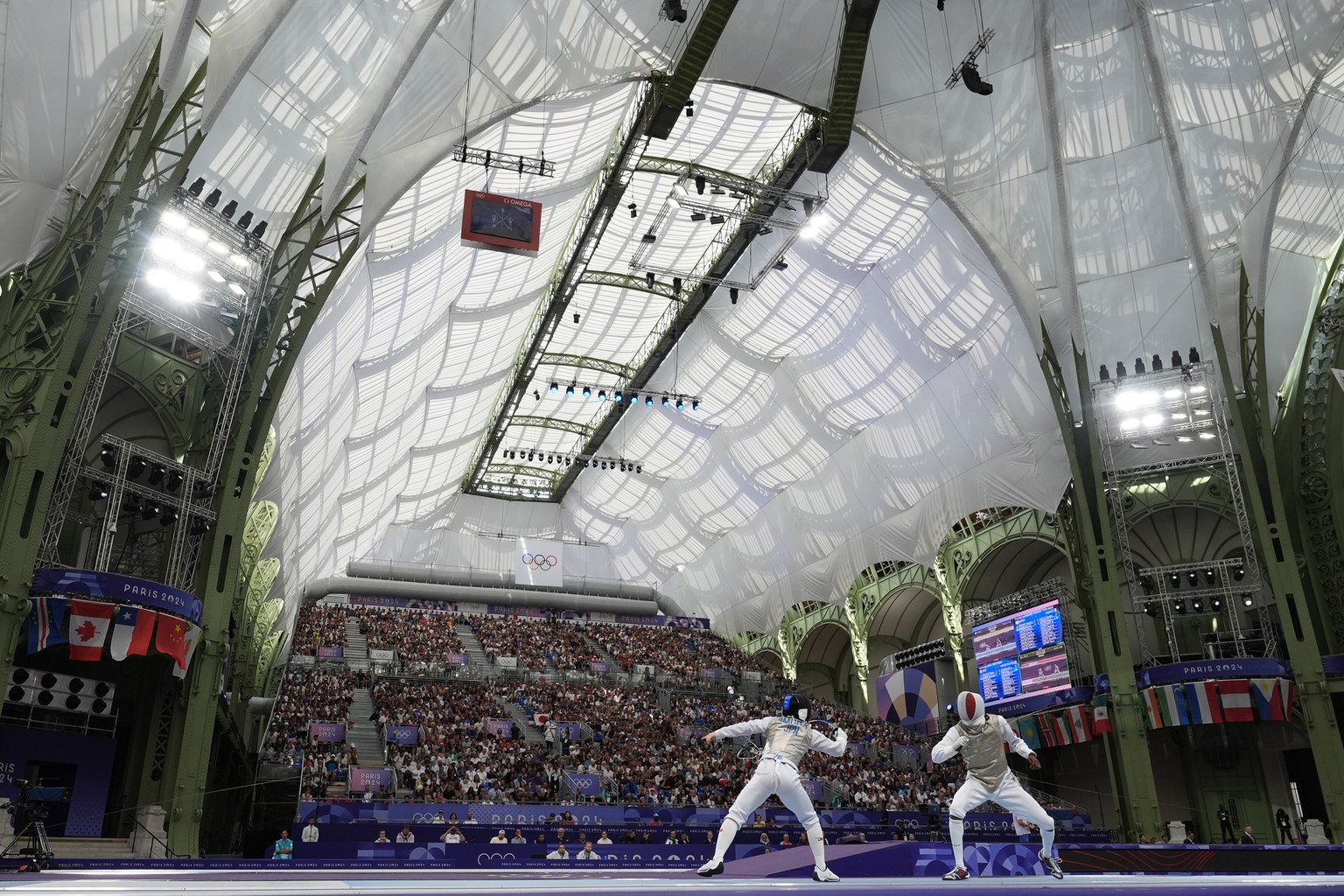 Japan&#039;s Kazuki Iimura competes with France&#039;s Maxime Pauty in the men&#039;s team foil semifinal match during the 2024 Summer Olympics at the Grand Palais, Sunday, Aug. 4, 2024, in Paris, Fra ...
