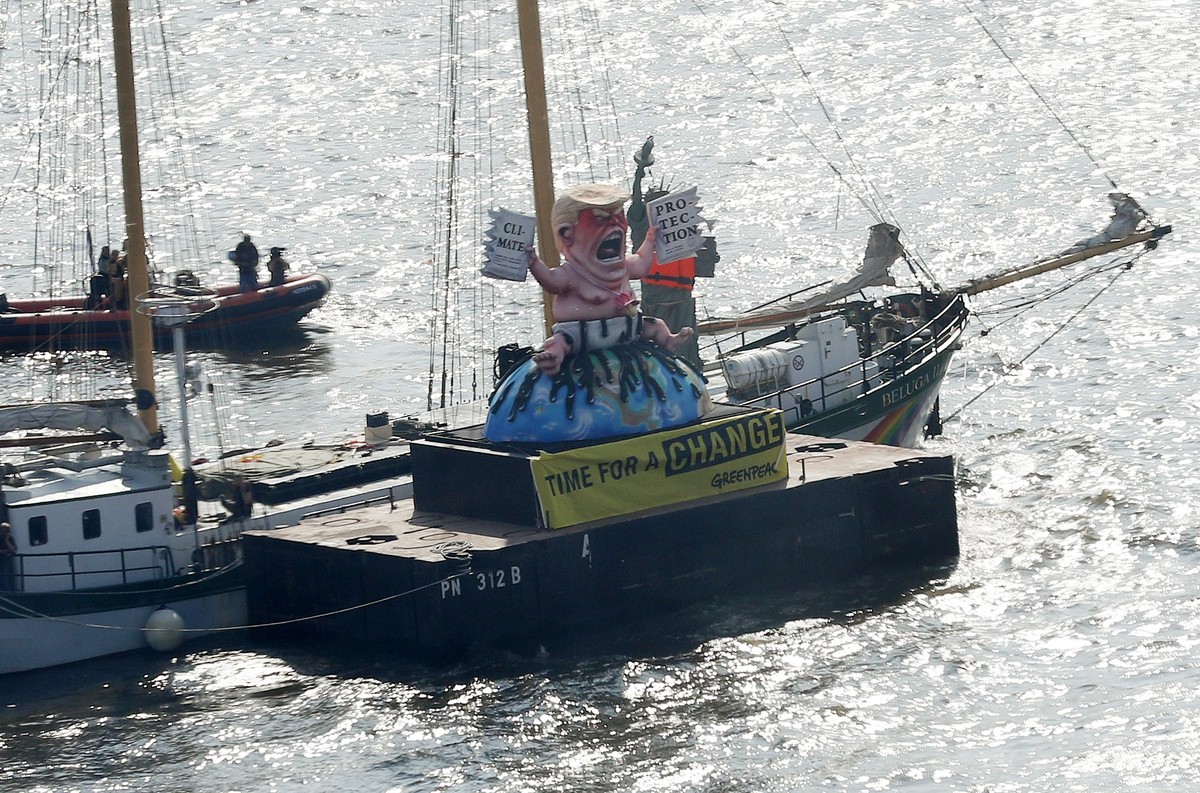 epa06073564 Greenpeace float with a mock depicting US President Donald J. Trump as a baby sitting on the earth and signs 'Climate Protection' and 'Time for a Change' during a prote ...