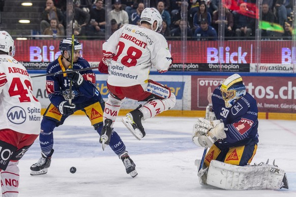 Torhueter Leonardo Genoni, rechts, von Zug im Spiel gegen Yannick-Lennart Albrecht, mitte, von Rapperswil beim Playoff Viertelfinal Spiel 4 beim Eishockey Meisterschaftsspiel der National League zwisc ...